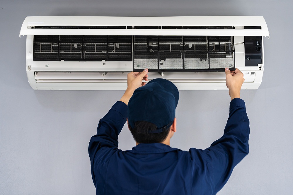 technician service removing air filter of air conditioner for cleaning